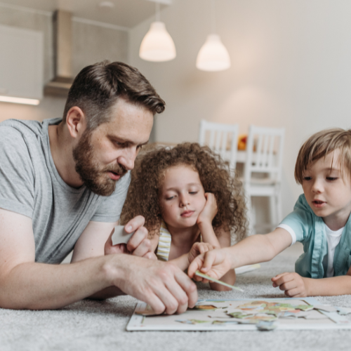 Vader en kinderen puzzelen